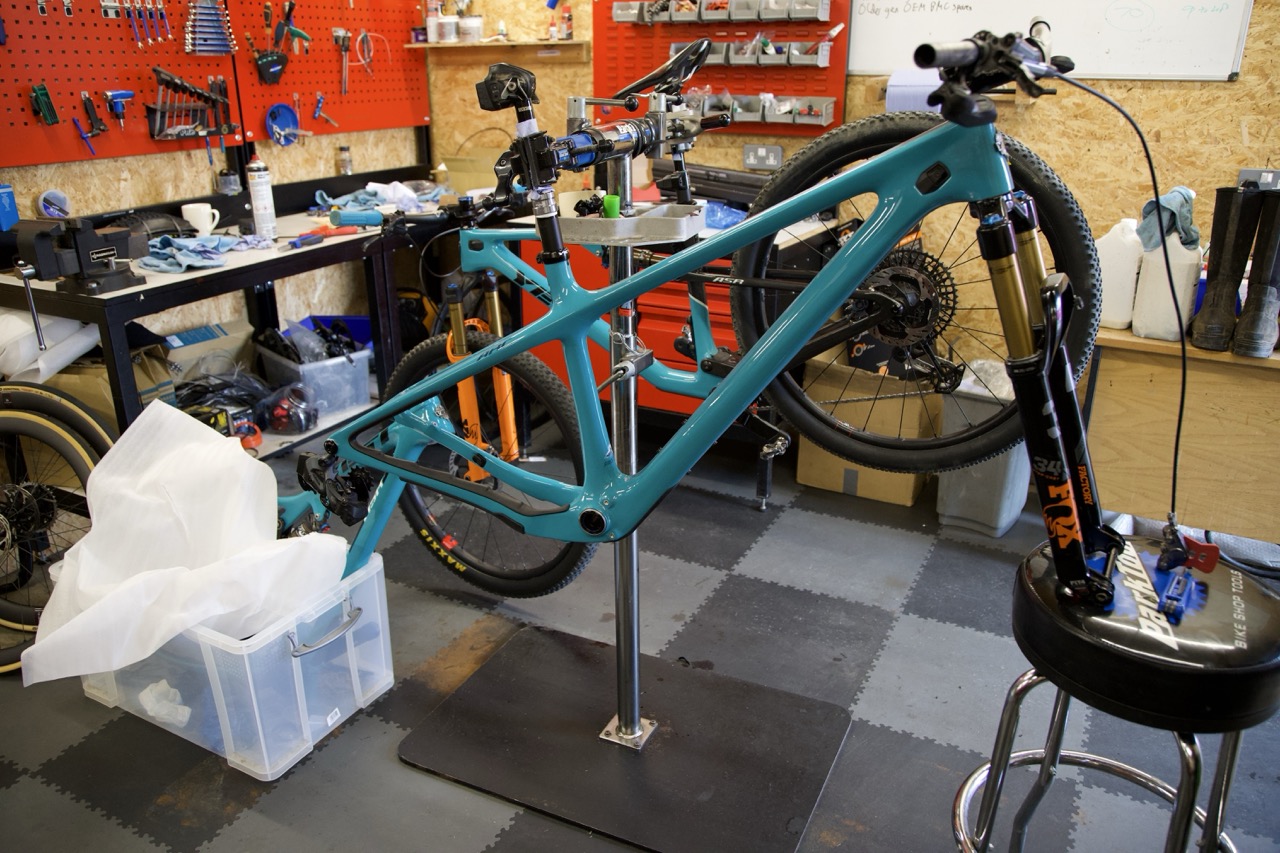 Turquoise Yeti ARC frame in the workshop stand with the serviced fork fitted